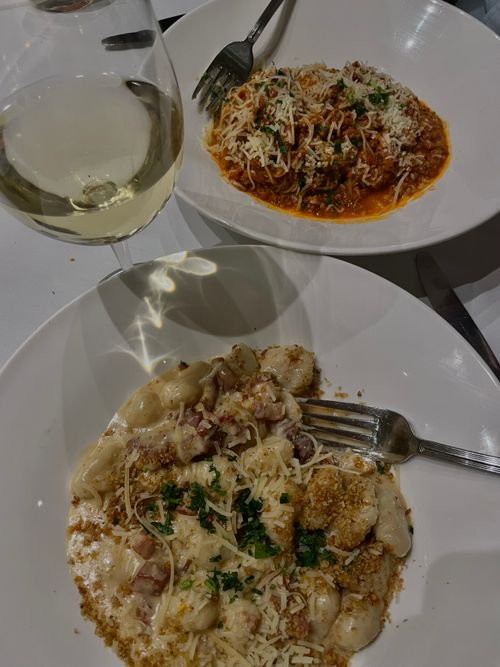 Free Top-down view of creamy pasta and wine, perfect for an elegant dinner setting. Stock Photo