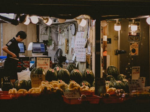 A man is standing in front of a market stall