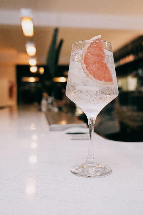 Free A crisp gin and tonic with a grapefruit slice served on a modern bar counter, perfect for a classy evening. Stock Photo