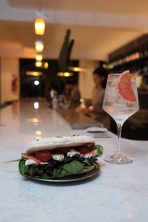 Close-up of an Italian Style Sandwich and a Cocktail Served in a Restaurant