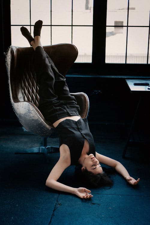 A woman is upside down in a chair