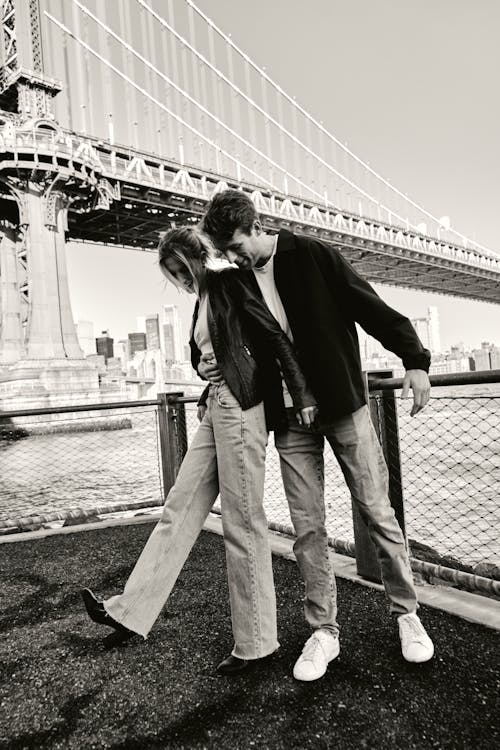 A couple standing in front of the brooklyn bridge