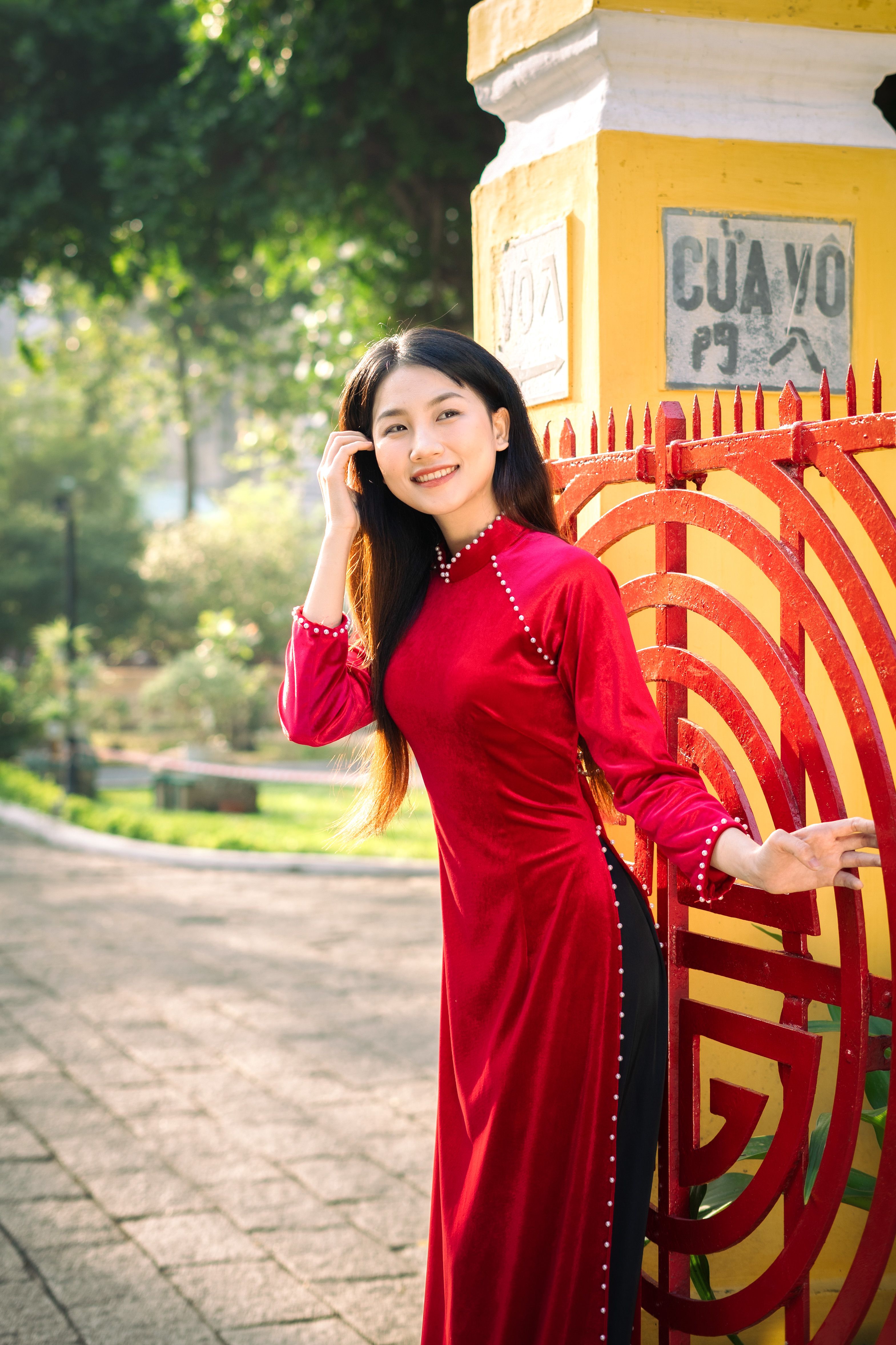 Brunette Woman in Red Dress Standing by Fence · Free Stock Photo