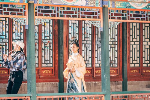 Two women in traditional chinese clothing standing on a balcony