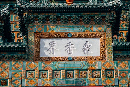 A chinese sign on a building with a blue roof