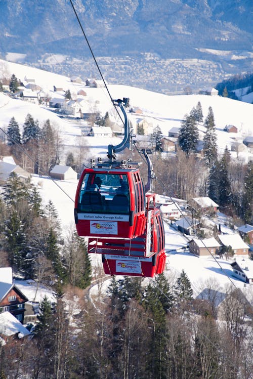 A cable car is going up a snowy hill