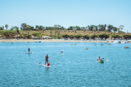 Free A vibrant day on the water with paddleboarders and kayakers enjoying the summer sun. Stock Photo