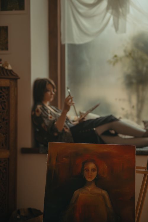 Free A focused artist painting in a cozy workshop by the window, embracing creativity. Stock Photo