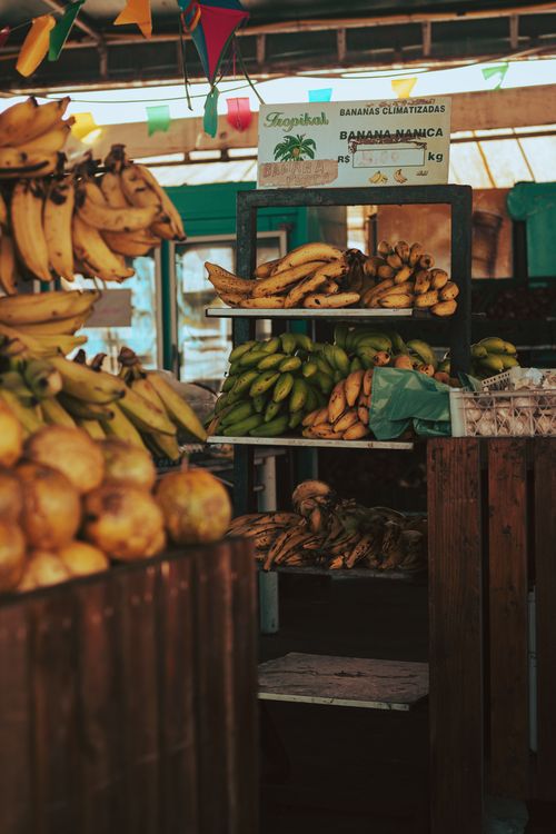 Free A colorful urban market showcasing diverse banana varieties, ideal for fresh produce scenes. Stock Photo
