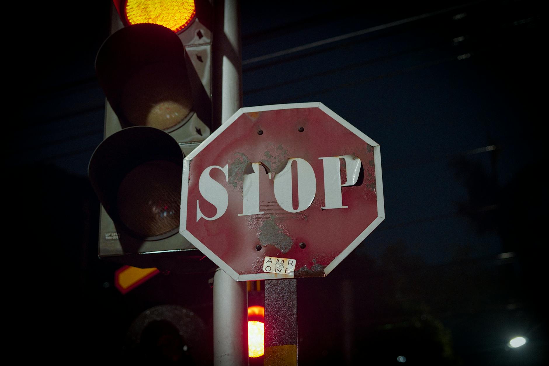 Stop sign beside traffic light at night