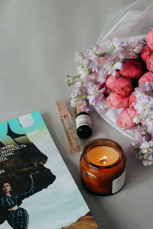 A book, candle and flowers on a table