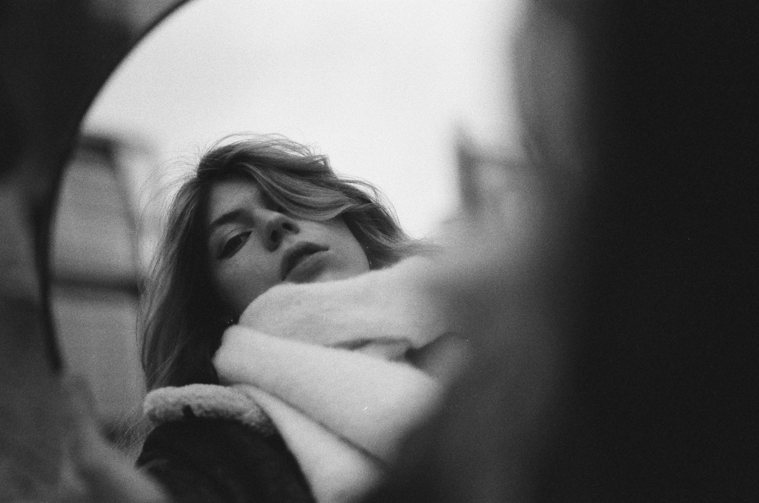 Stylish black and white portrait of a woman reflected in a mirror, captured in Berlin.