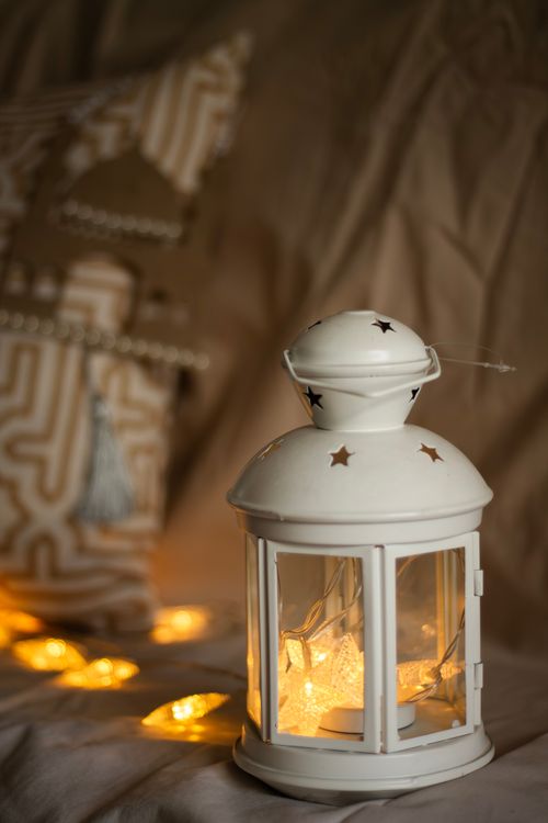 Free A warm glow from a star-cut white lantern adds cozy ambiance to a decorative room setting. Stock Photo