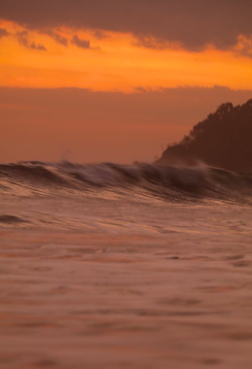 Foto profissional grátis de água, água branca, céu alaranjado