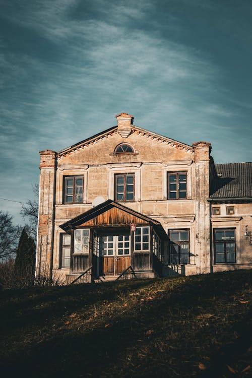 An old house with a porch and a grassy field