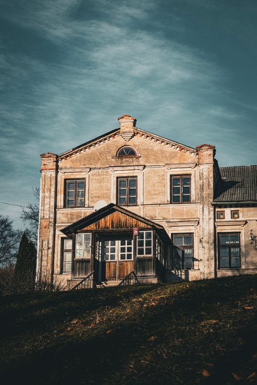 Free A vintage-style, abandoned rural house under a clear blue sky, perfect for historical or architectural themes. Stock Photo