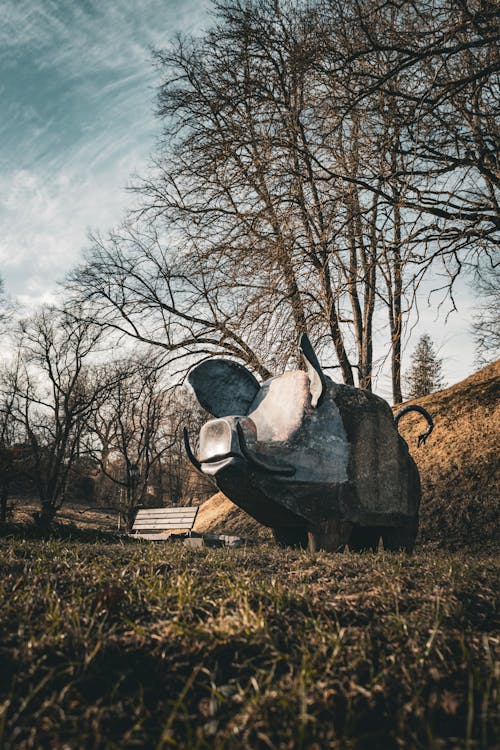 A metal sculpture of a pig in the grass