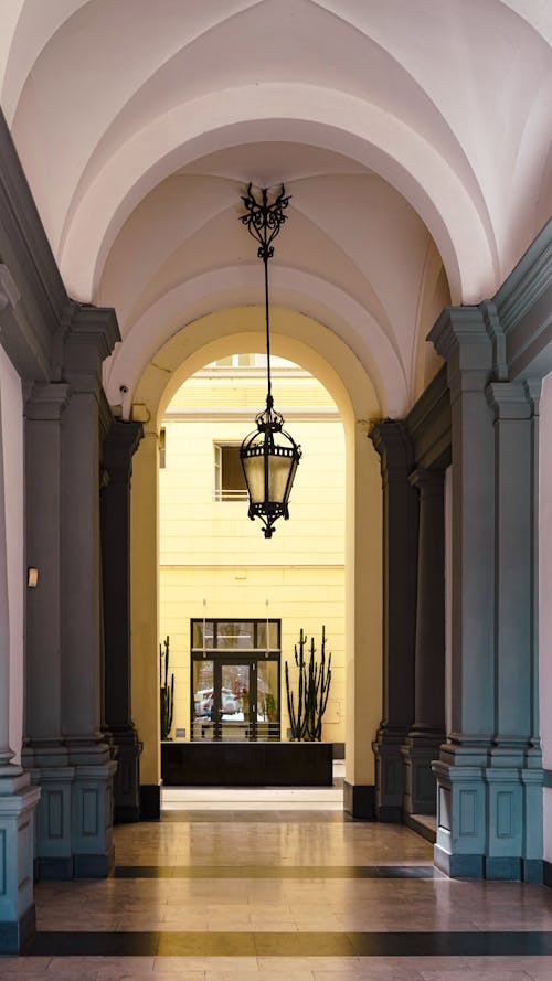 A hallway with a light fixture and a lamp