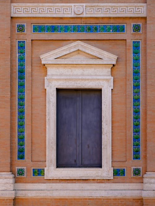 A window with a blue door and green tiles