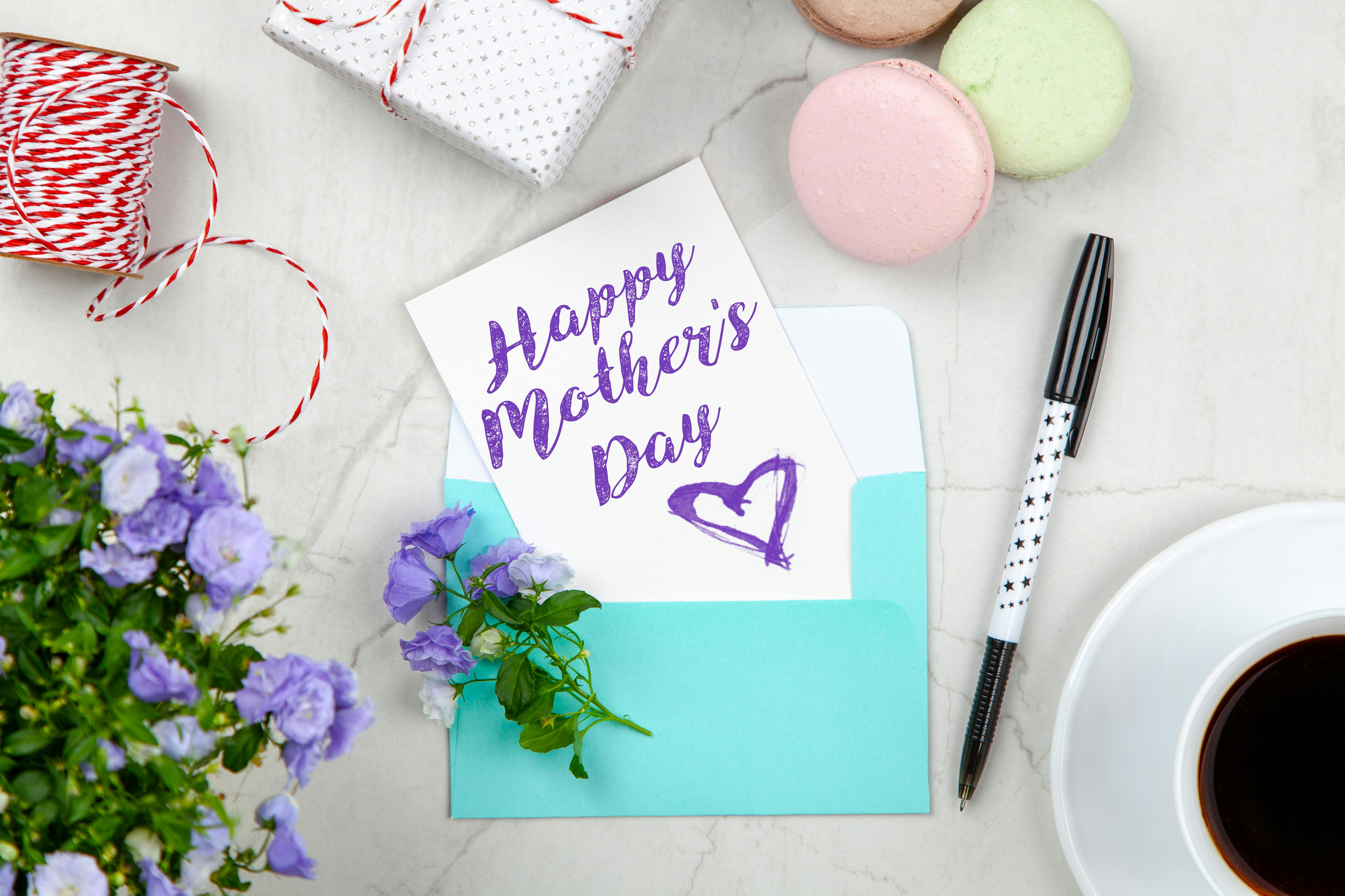 Happy Mothers Day Card Beside Pen, Macaroons, Flowers, and Box Near Coffee  Cup With Saucer · Free Stock Photo