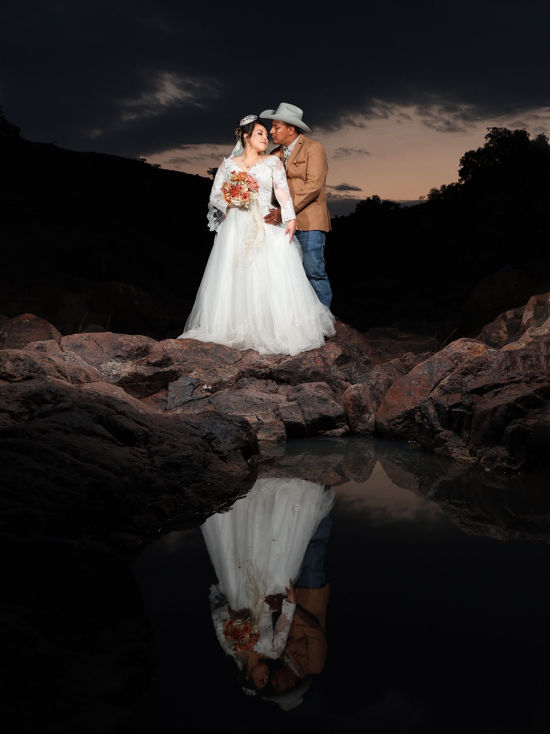 Newlyweds share a tender moment on rocky grounds at twilight, San Felipe, Mexico.