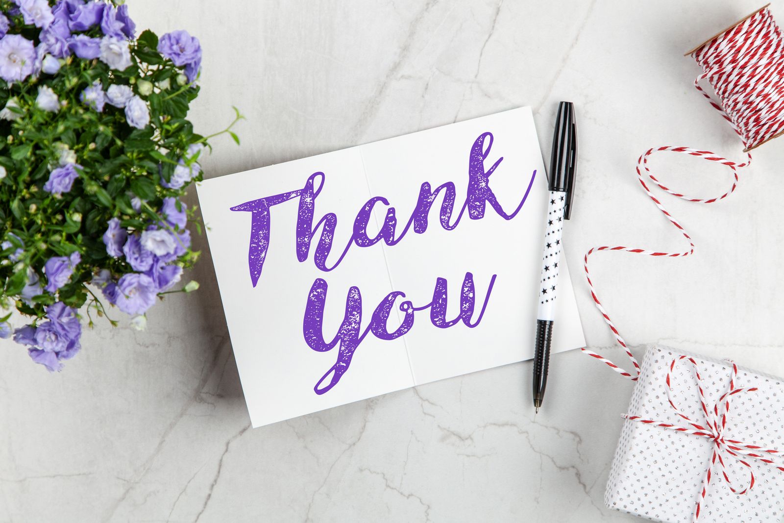 A handwritten 'Thank You' card on a desk — the kind of small gesture that turns a finished project into a referral