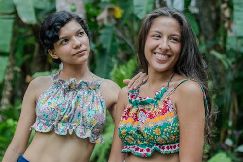 Two women in colorful tops standing next to each other