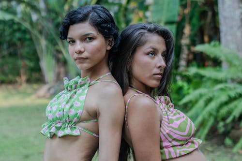 Two women in matching green and pink bikini tops