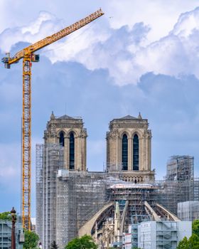 A view of Notre-Dame Cathedral under restoration with a tower crane in Paris, France.