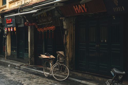 Free An old bicycle parked on a rainy day in a quiet, atmospheric city street. Stock Photo