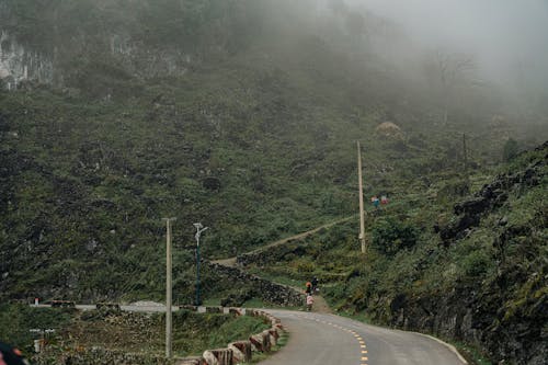 A person riding a motorcycle on a road in the mountains