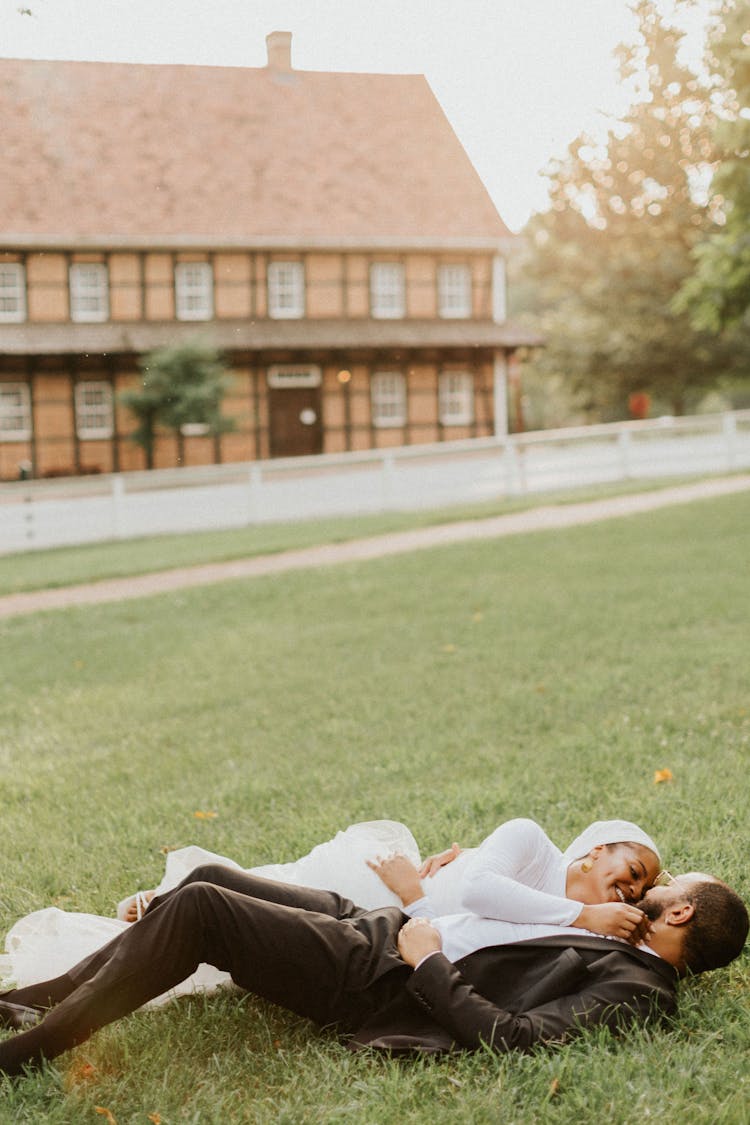 Wedding Couple Lying On A Grass 