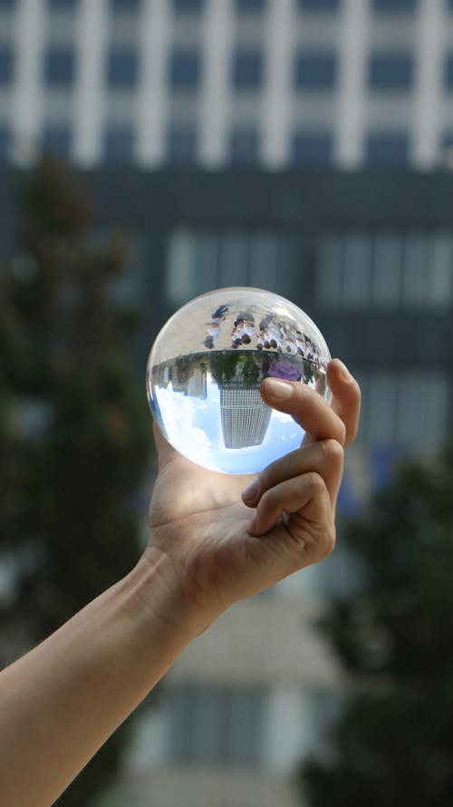 A person holding a glass ball in their hand