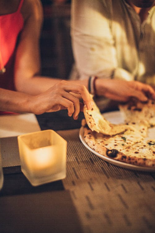 Person Holding Pizza Slice