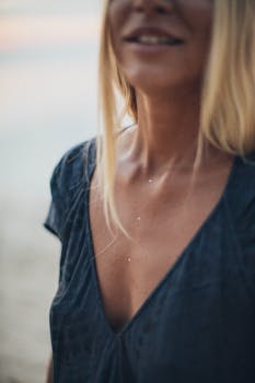 Close-up of a fashionable young woman with blond hair and tan skin at the beach.