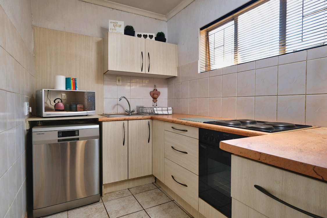 A small kitchen with a stove, sink and microwave