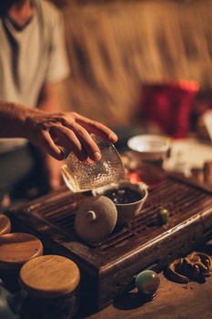 Artisan pouring tea in traditional setup in Thailand. Warm, vintage atmosphere.