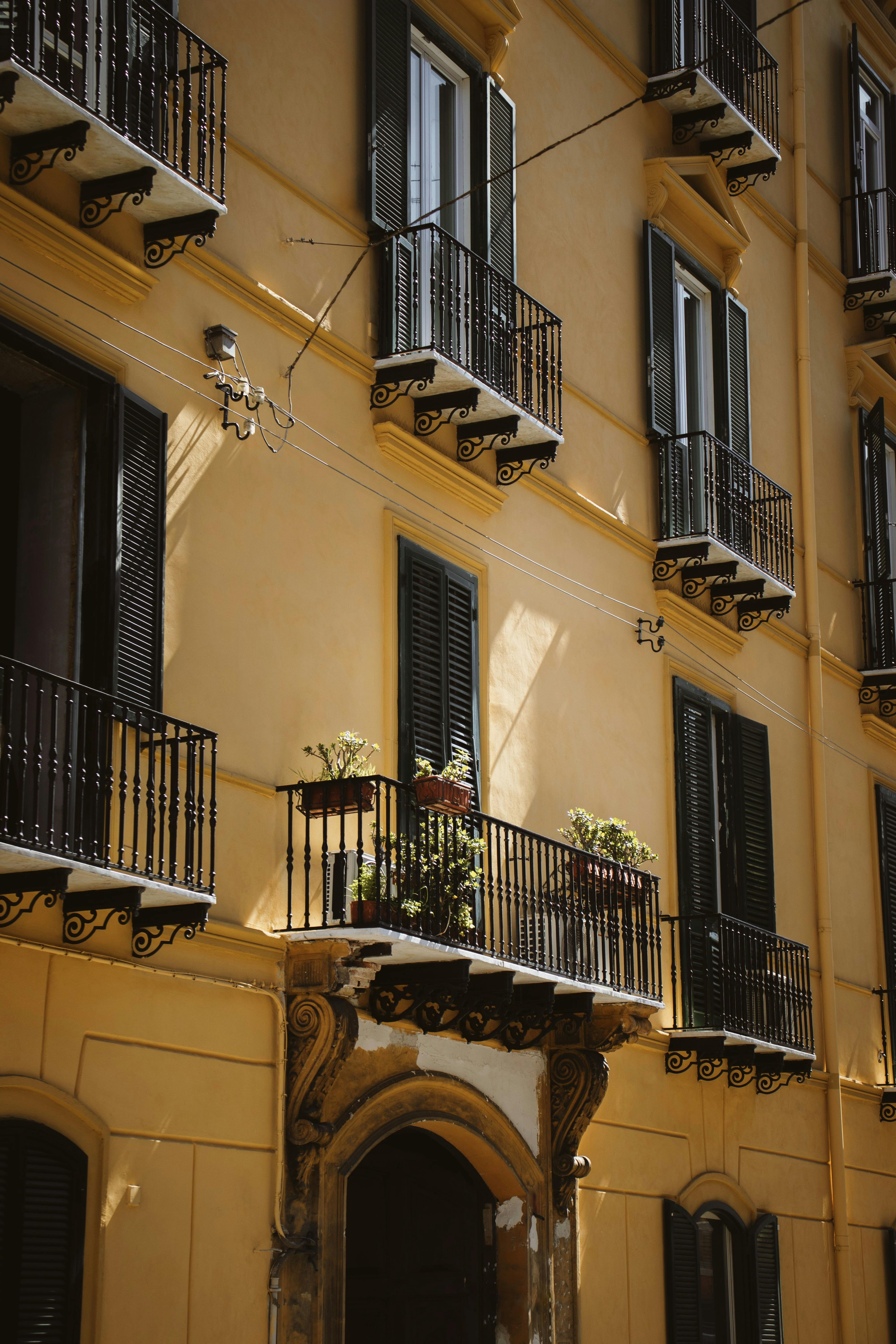 Elegant residential building facade with balconies in Naples, Campania, Italy bathed in warm light.