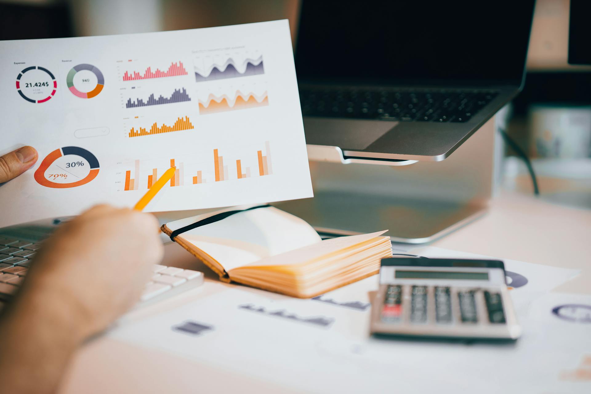 Man Hand with Pencil Holding Sheet with Graphs