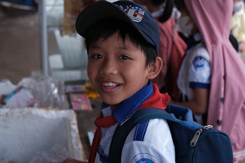 A young boy in a school uniform smiling