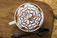 咖啡杯顶视图，泡沫木桌上饰有复杂的巧克力设计