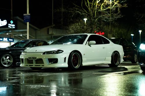 Free White sports car parked on wet city street at night in Southampton, UK, showcasing urban nightlife. Stock Photo
