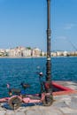 A pink scooter parked near a pier with a view of the water