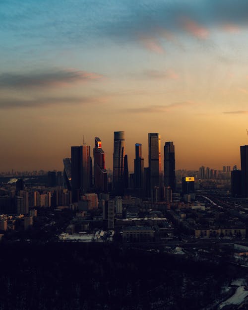 A city skyline at sunset with a large building in the foreground