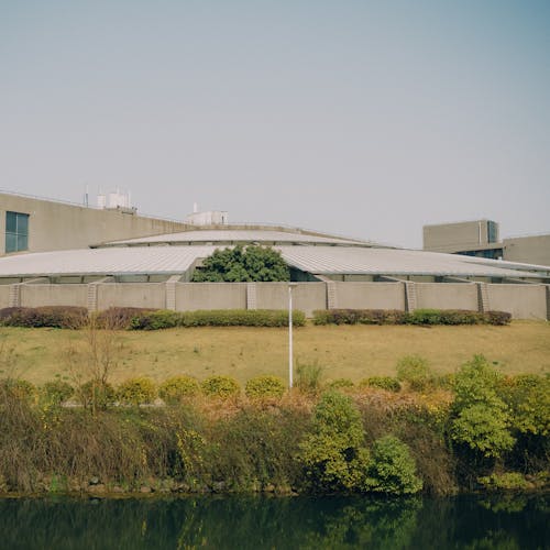 A large building with a green roof and a pond