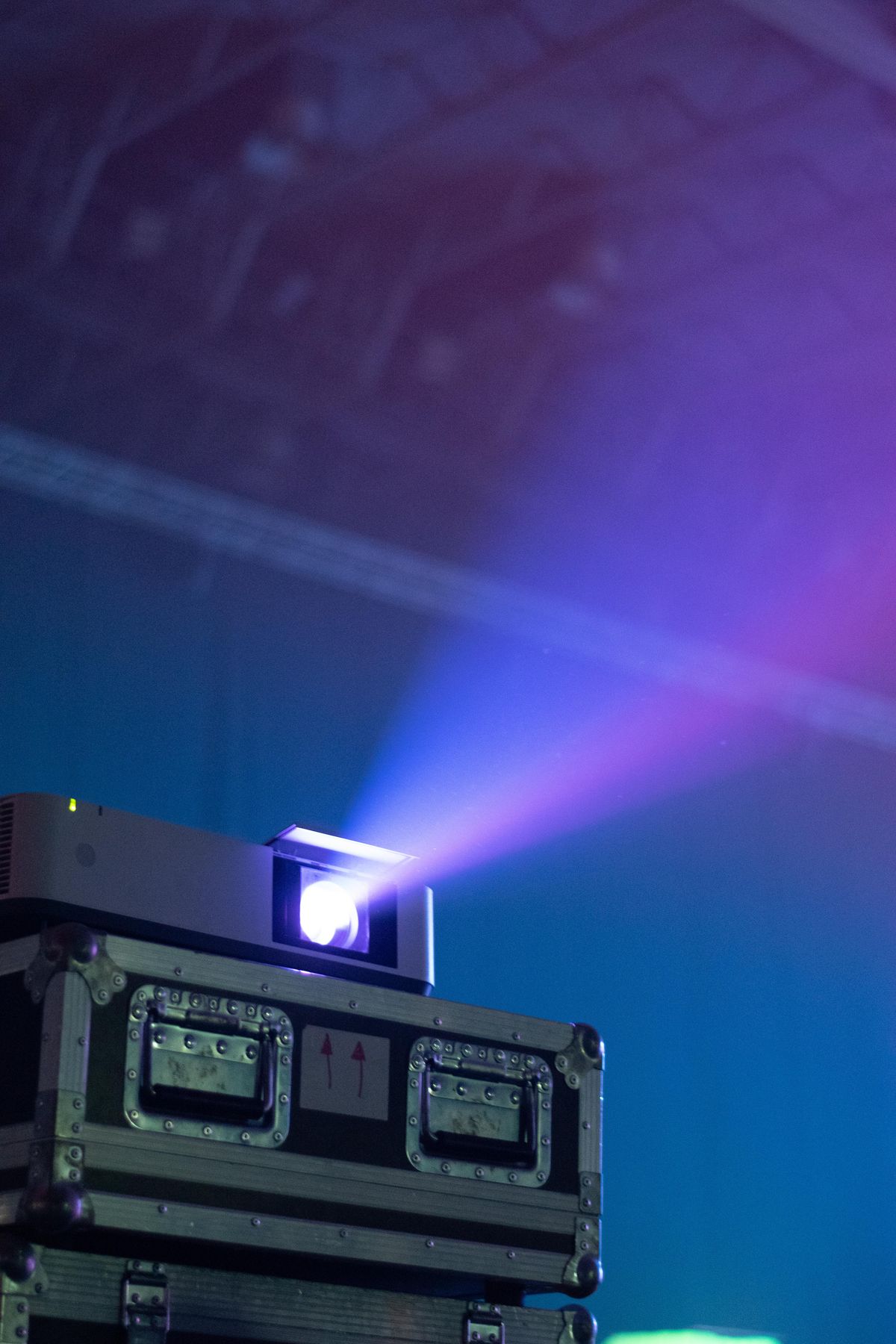 Projection and beam unit mounted on a road case, casting a beam through haze
