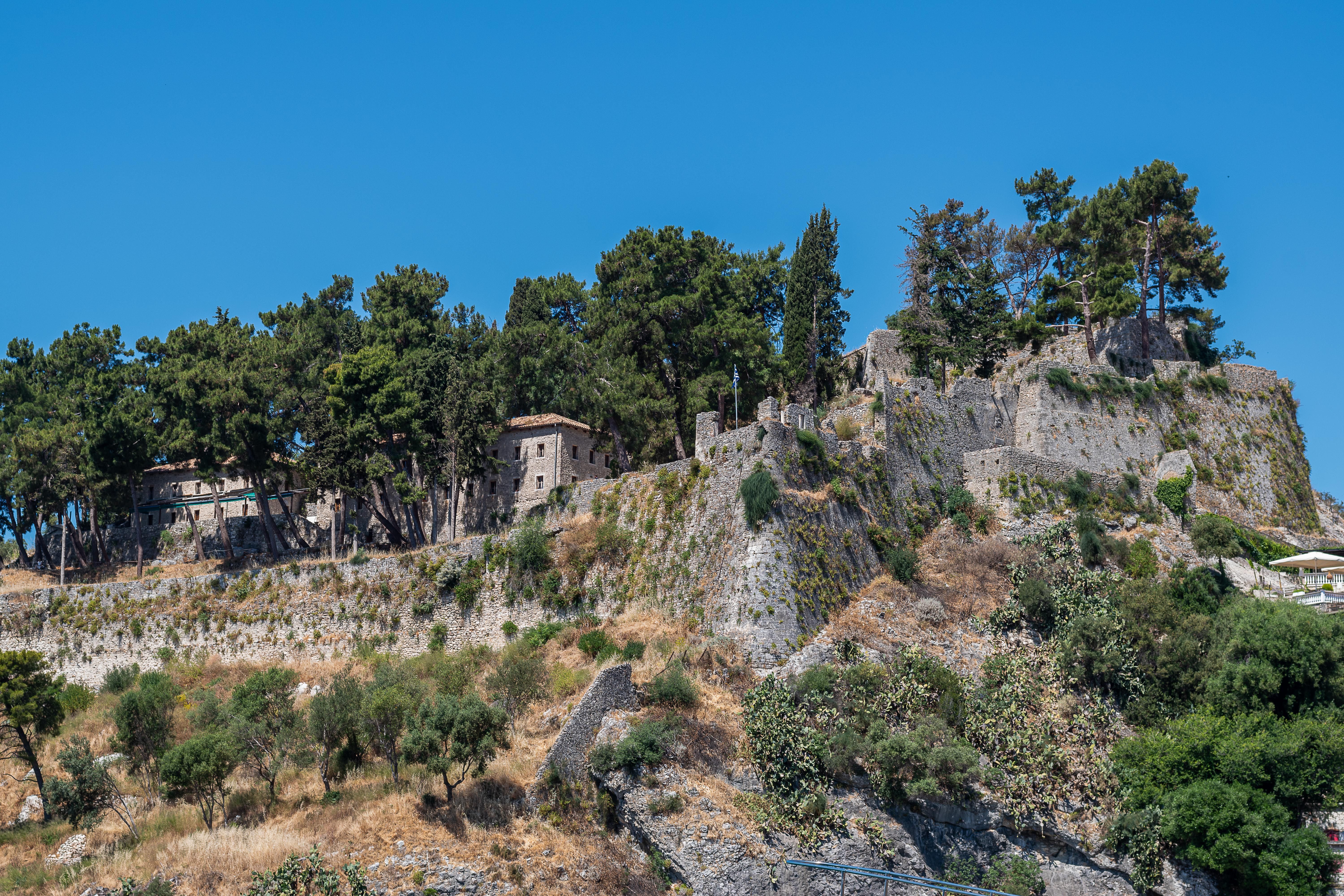Explore the historic castle ruins on a scenic hilltop in Parga, Greece, surrounded by lush greenery.