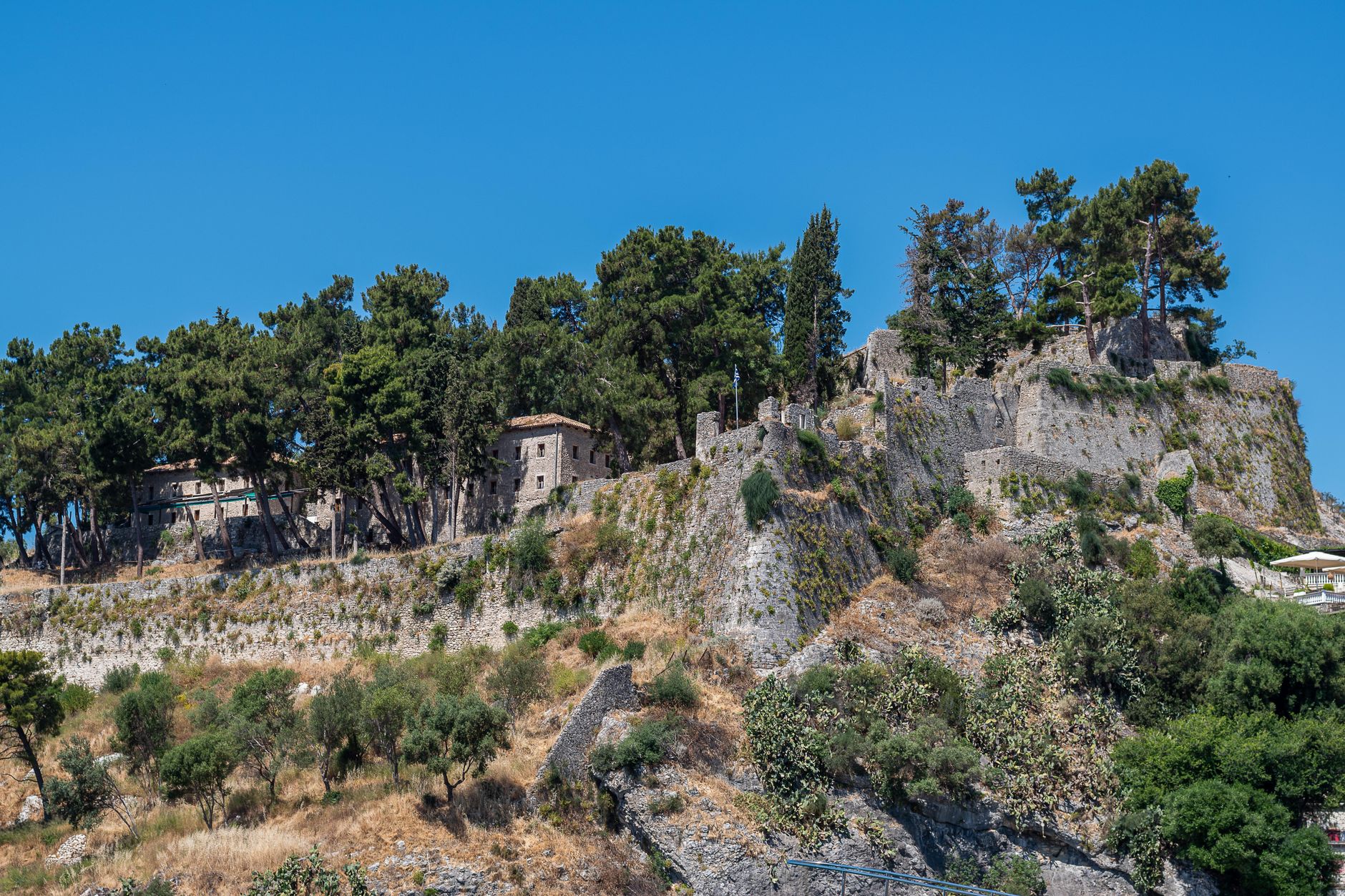 Explore the historic castle ruins on a scenic hilltop in Parga, Greece, surrounded by lush greenery.