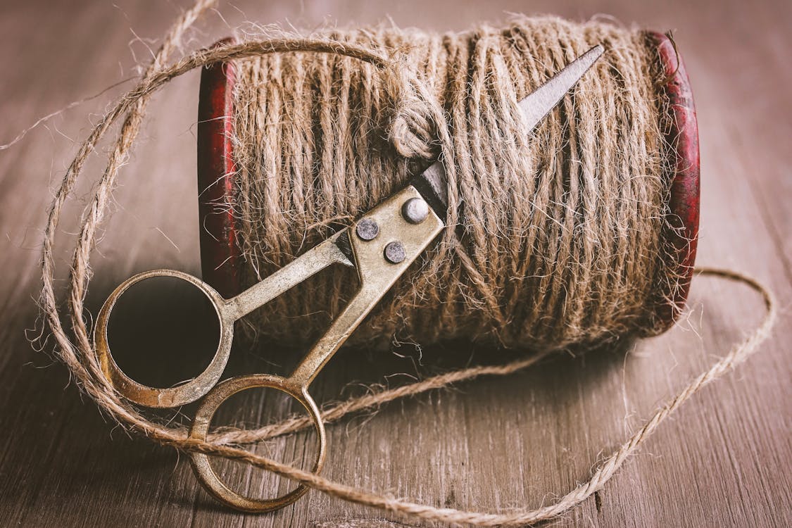 Scissors cutting Brown Thread 