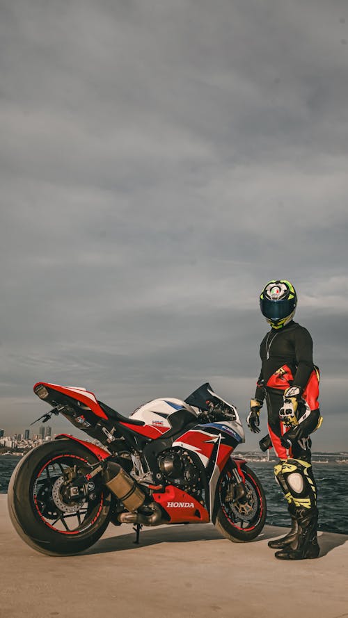 Man in a Helmet Next to a Honda CBR1000RR on the Wharf